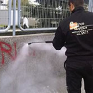 tecnico de limpieza eliminando graffiti de pared mediante agua a presion